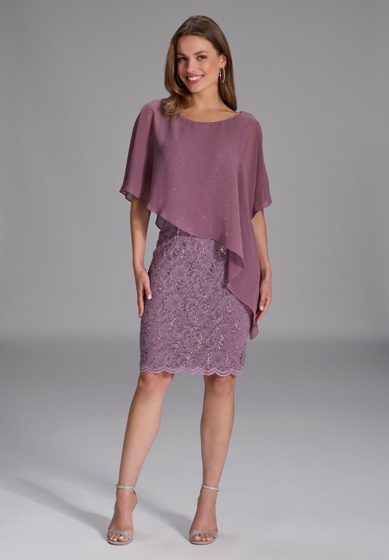 Purple dress with lace detailing and sequins, paired with a semi-sheer, draped overlay. Features scalloped hem and silver sandals.