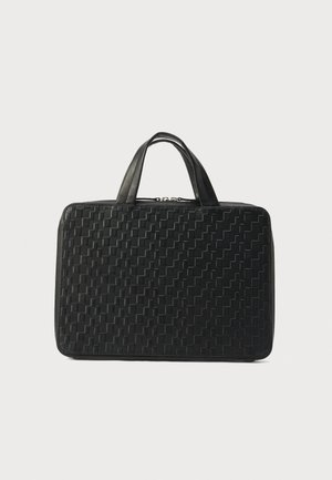 Mustast nahast portfell tekstuurse geomeetrilise mustriga ja kahekordsete käepidemetega, mis seisab püsti heledal taustal.