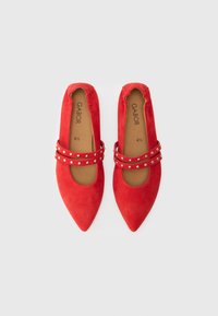 Piros velúr balerina enyhén hegyes orral, két ezüst szegeccsel díszített pánttal. A talpbetéten látható a "Gabor" márkanév.