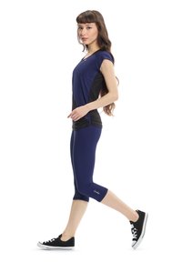 Navy athletic top with black accents, short sleeves, paired with navy capri leggings and black sneakers. Smooth fabric, fitted design.