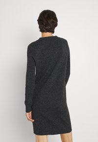 Tmavě šedé pletené šaty, dlouhé rukávy, kruhový výstřih, uvolněný střih, žebrované manžety, délka po kolena, hladká textura, minimalistický design.