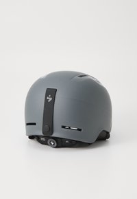 Gray helmet with a matte finish, featuring ventilation slots, a rear adjustment dial, and a logo on the back strap for easy size adjustment.