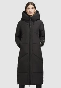 Manteau d'hiver noir long en duvet avec un col montant et une fermeture éclair. Il présente des coutures horizontales et diagonales, des poches latérales et une texture lisse.