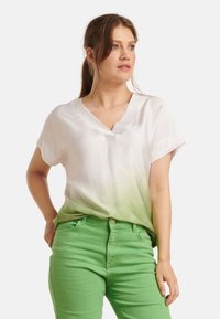 White to green ombré blouse with a loose fit and V-neck, paired with fitted green pants. Smooth texture and short sleeves.