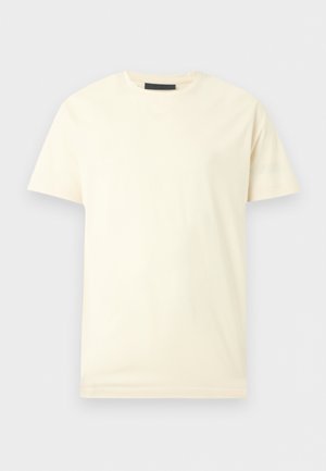 Eenvoudig T-shirt met korte mouwen en ronde hals in off-white, plat gelegd op een lichtgrijze achtergrond.