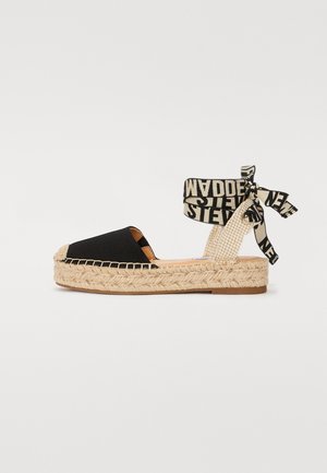 Černé plátěné espadrilky s pletenou juteovou podrážkou, se silným podpatkem a vzorovaným řemínkem kolem kotníku. Řemínek se uvazuje kolem kotníku.