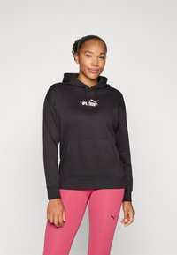 Svart hettegensere med snøring og kengurulomme, med en hvit Puma-logo. Kombinert med rosa leggings som viser en liten logo.