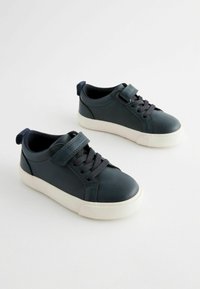 Mörkblå lädersneakers med vita gummisulor, utrustade med snören och ett kardborreband. Designade med rundad tå och en dragrem baktill.