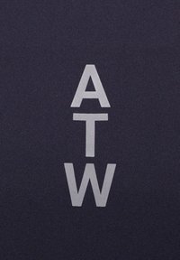 Navy-Stoff mit fettgedrucktem, hellgrauem Text, der "ATW" in gestapelter Anordnung zeigt. Glatte Textur mit einem minimalistischen Design.
