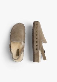 Zuecos de ante en color topo con un suave forro de piel de oveja. Diseñados con una correa y tachuelas metálicas decorativas a lo largo del costado. Suela plana de goma.