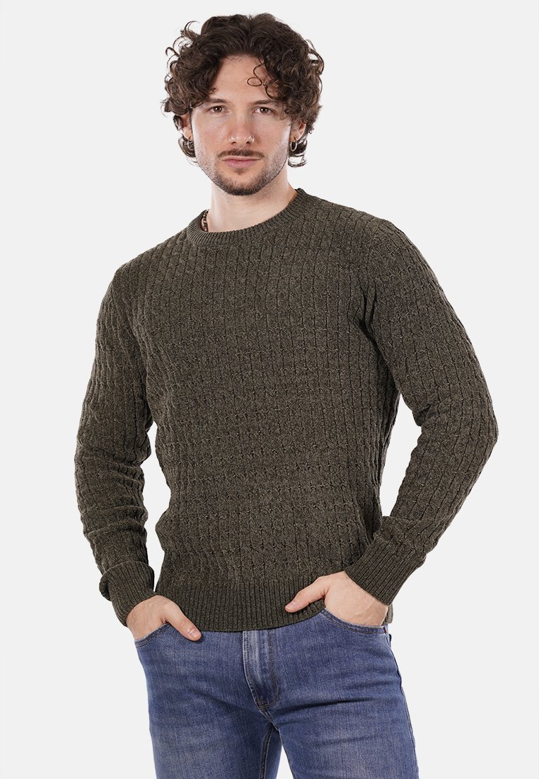 Suéter verde oliva de punto con patrón texturizado, cuello redondo y puños acanalados. Combinado con vaqueros azules, que muestran un ajuste casual.