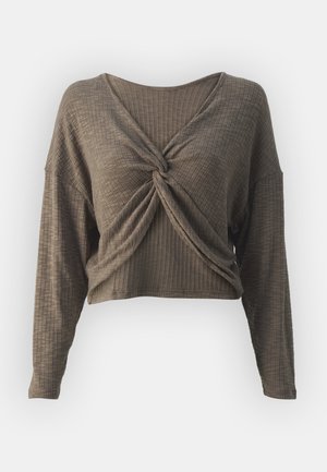 Pruun ribast pikka varrukaga crop top, millel on keeratud eesmine disain ja V-kujuline kaelus, valmistatud pehmest, tekstuuriga kangast.