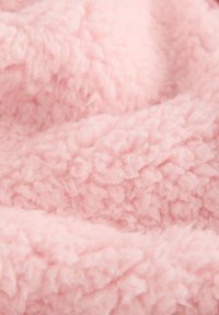 Tessuto rosa morbido e soffice con una superficie strutturata e riccia, simile a pile o sherpa.