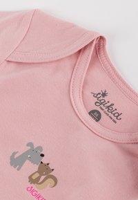 Pink cotton t-shirt featuring a gray dog and brown fox graphic, round neckline, and smooth texture. Brand label "sigikid" visible.