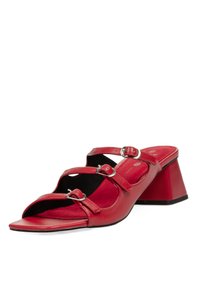 Sandalias de tacón de cuero rojo con punta abierta, tres correas ajustables con hebillas y una plantilla texturizada. Terminadas con un tacón cónico resistente.