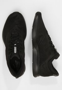 Baskets de course noires avec une tige en mesh pour la respirabilité, un col rembourré, des lacets plats et une semelle en caoutchouc texturée pour une meilleure adhérence.