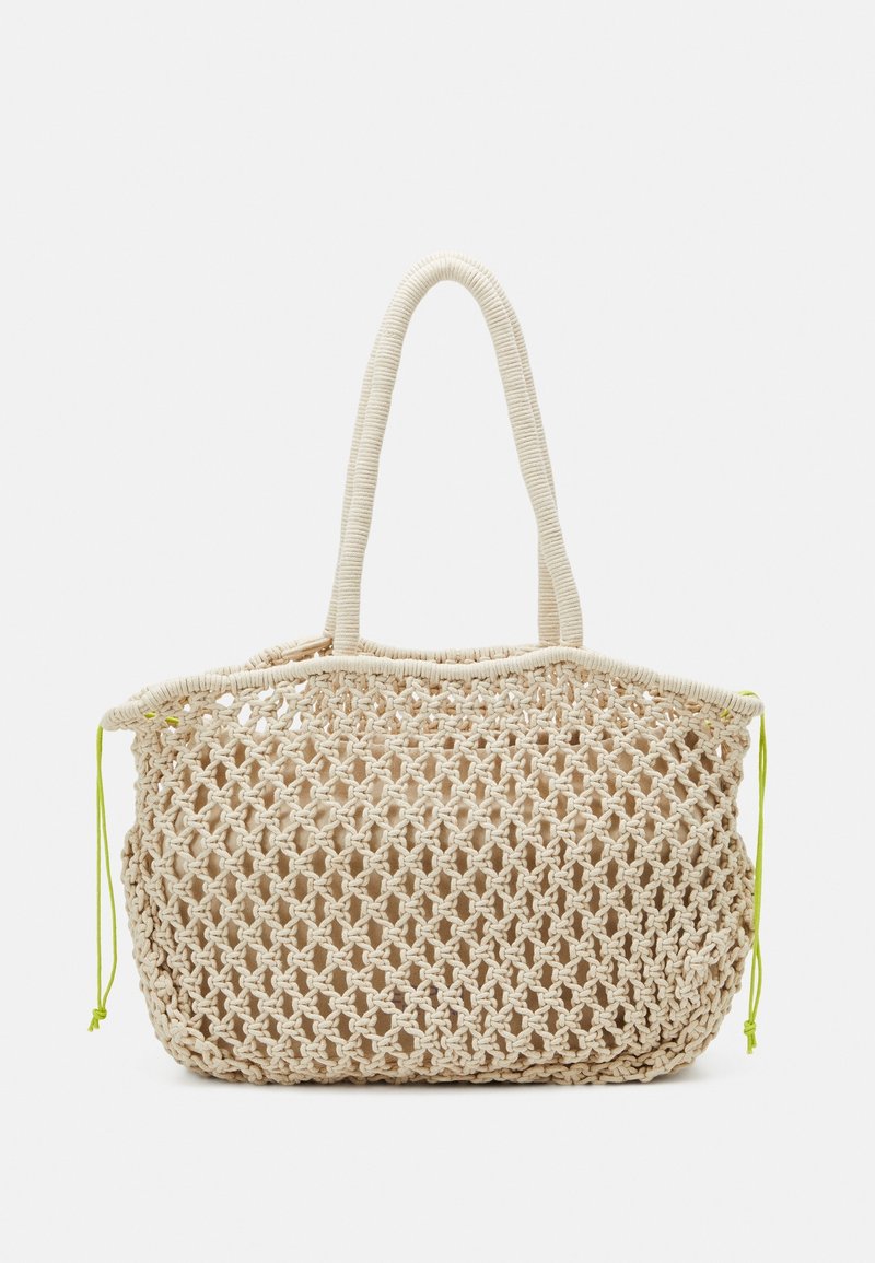 Sac fourre-tout à maille ouverte en fibres naturelles, de couleur beige, avec deux poignées et des accents de cordon de serrage vert néon le long du bord supérieur.