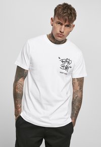 White cotton t-shirt featuring a black graphic print on the left chest saying "BAD BOY NEW YORK." Classic crew neckline and short sleeves.