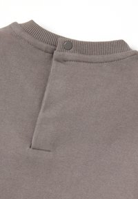 Grijze gebreide trui met een geribbelde kraag en een knoopdetail aan de achterkant. De stof lijkt zacht met een gladde textuur en minimale stiksels.
