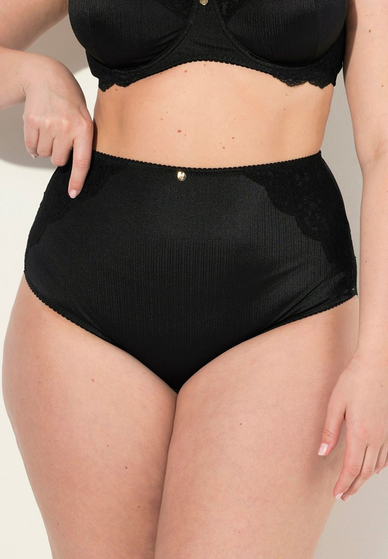 Hoge zwarte onderbroek met geribbelde textuur en kanten accenten aan de zijkanten. Gouden knoopdetail aan de voorkant, boven de tailleband.