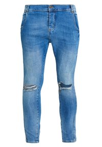 Vaqueros de corte slim de color azul claro con desgastes en ambas rodillas, bolsillos frontales y cierre con botón en la cintura.