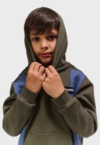 Olivgrüner Kapuzenpullover mit blauen Akzenten. Verfügt über eine Fronttasche, gerippte Bündchen und ein Logo-Patch auf der Brust. Weicher, strukturierter Stoff.