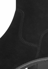 Stivale alla caviglia in suede nero dal design elegante, con cuciture a contrasto e una suola in gomma testurizzata per una buona presa.