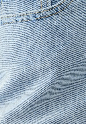 Heled sinine denimkangas, millel on veidi tekstureeritud pind, diagonaalis kootud mustritega ja näärinud servadega õmbluse lähedal.