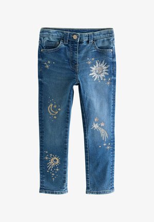 Modre denim jeggingse z oprijetim krojem, ki vsebujejo metalne vezenine z zvezdami, soncem in luno na hlačnicah. Standardna zasnova s petimi žepi.