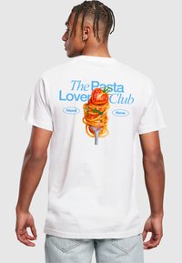 White cotton t-shirt featuring a graphic of spaghetti on a fork, with red peppers and green herbs. Text reads "The Pasta Lover Club" in blue.