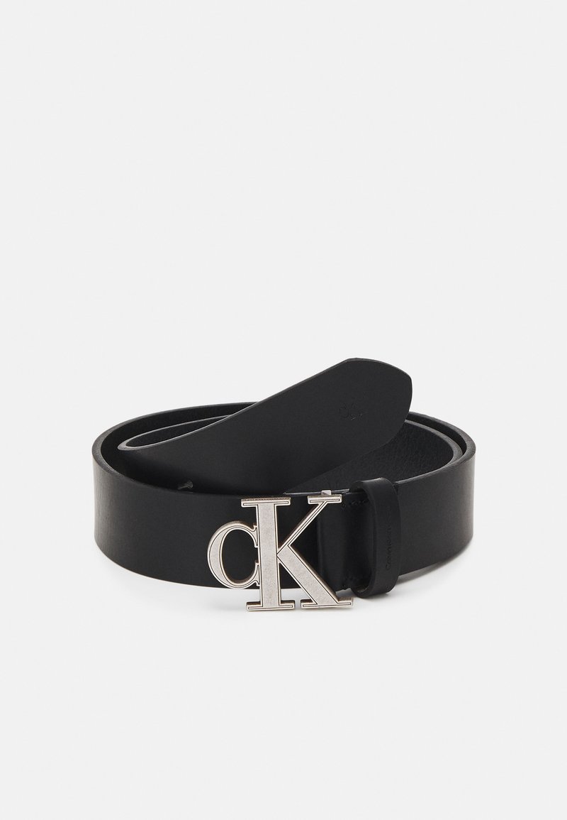Cintura in pelle nera con una fibbia lucida in argento con il logo "CK". La fascia è liscia con una leggera lucentezza e un design semplice.
