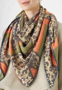 Écharpe multicolore ornée d'un motif géométrique et de feuillage en beige, vert, orange et marron. Finition avec un bord cousu bleu marine.