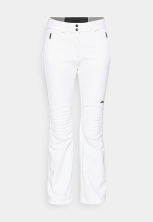 Calças brancas feitas de tecido macio, com um design ajustado, detalhes canelados nos joelhos, bolsos laterais com fecho e um logótipo na parte inferior da perna.