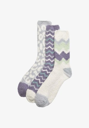 Tres pares de calcetines de peluche en tonos de púrpura, gris y blanco con patrones variados: estampado de guepardo, zigzag y ondas. Tejido suave y texturizado.