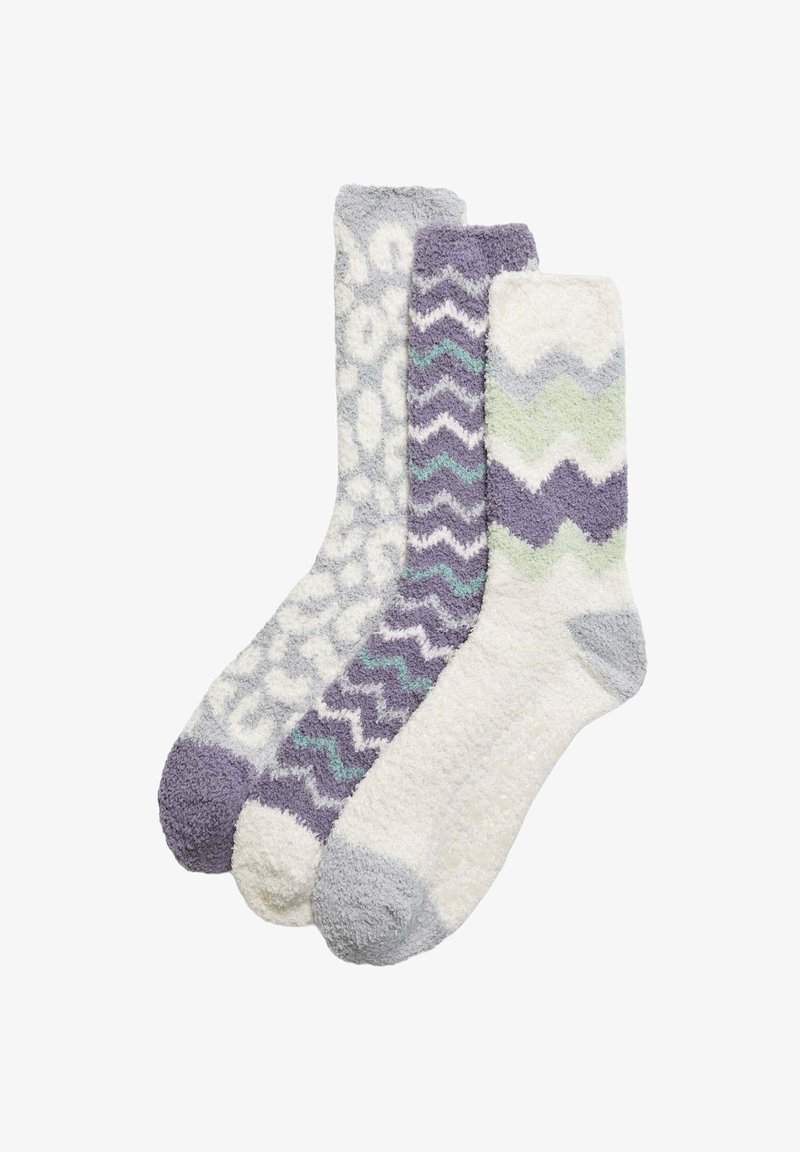 Tres pares de calcetines de peluche en tonos de púrpura, gris y blanco con patrones variados: estampado de guepardo, zigzag y ondas. Tejido suave y texturizado.