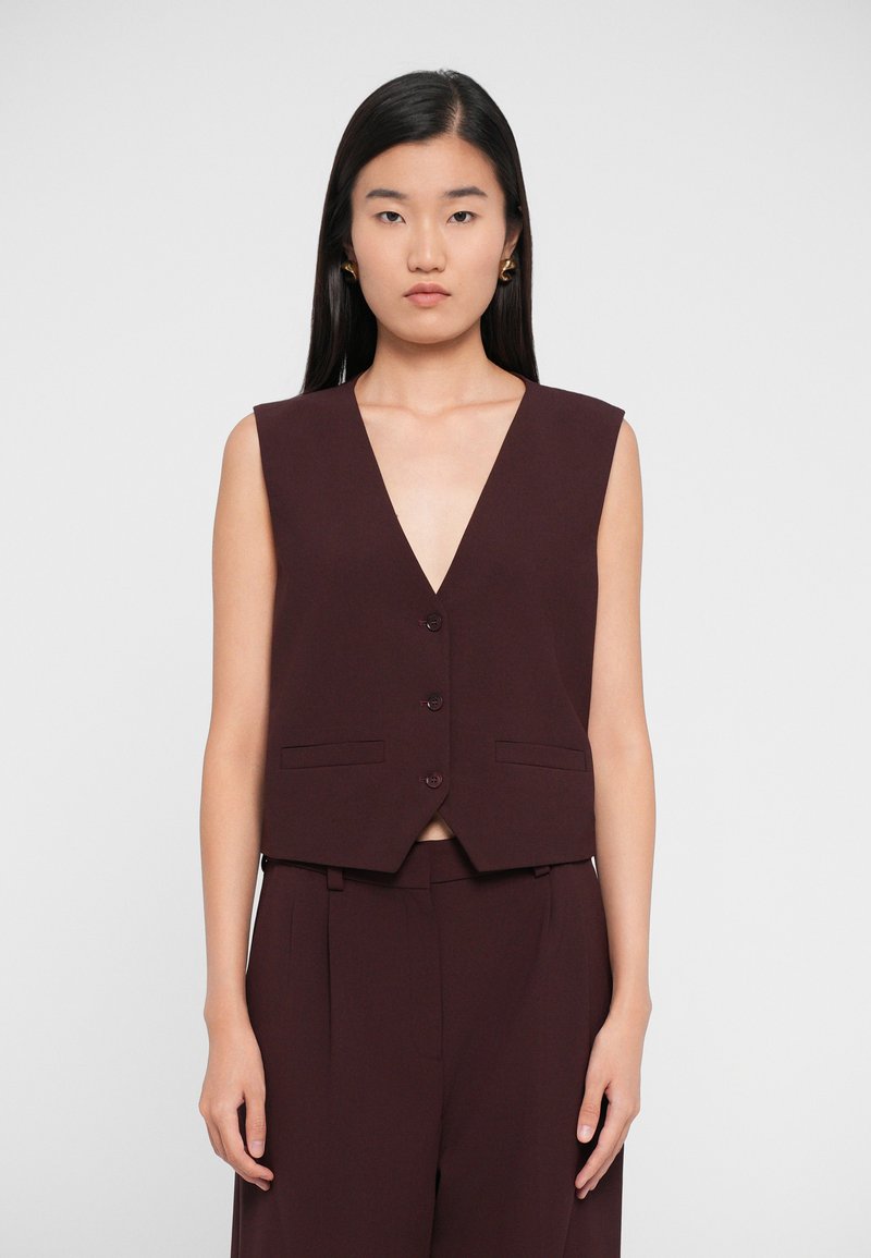 Burgundy sleeveless vest with a deep V-neck, front buttons, and two pockets, featuring a structured design and smooth texture.