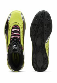 Scarpe da ginnastica verde neon con accenti neri e bianchi, superficie testurizzata e lacci rosa. Presentano una suola in gomma con motivi arrotondati.