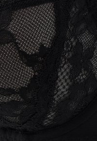 Black lace fabric with floral patterns, featuring a fine mesh texture. Subtle sheen and layered detailing visible in the design.