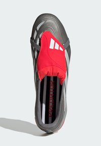 Szürke sportcipő piros, zokniszerű felsőrésszel, fehér átlós csíkokkal és texturált felülettel. Párnázott talpbetéttel rendelkezik.