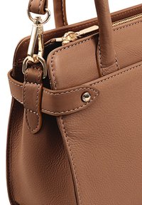 Bruine leren handtas met een gestructureerde afwerking, voorzien van gouden hardware, stikseldetails en een afneembare schouderband. Ritscompartiment zichtbaar.