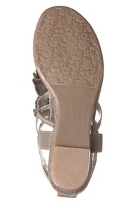 Sandal s plochou, texturovanou gumovou podrážkou s květinovými vzory. Svršek tvoří kovové stříbrné pásky s pevnou přezkou kolem kotníku.