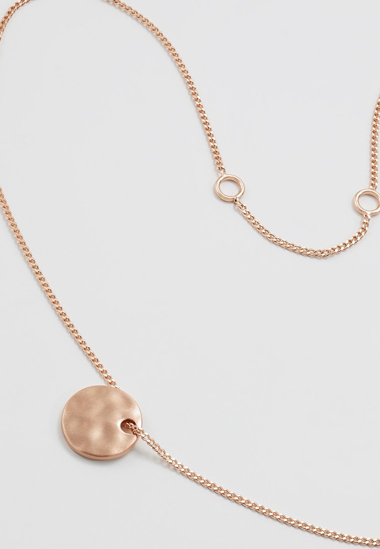 Collier en chaîne en or rose avec un pendentif circulaire plat et deux petits maillons ronds sur fond blanc.