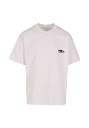 White cotton t-shirt featuring short sleeves, a crew neckline, and a small black printed logo on the left side of the chest.