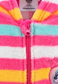 Chaqueta de forro polar con cremalleras en colores rosa, amarillo, blanco y azul; presenta una cremallera rosa y un parche de personaje en un lado.