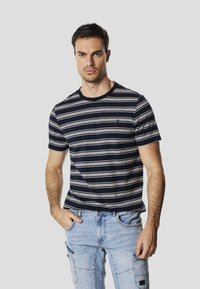 T-shirt à manches courtes rayé bleu marine et blanc, avec encolure arrondie et détail de logo brodé sur la poitrine, côté gauche.