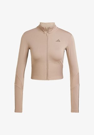Beige athletic crop jacket with a high collar, full zip, ribbed texture on sleeves and lower hem, featuring a small logo on the chest.