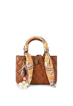 Brązowa pleciona skórzana torebka z rączką owiniętą pomarańczowym szalikiem w wzory oraz zawieszkami w kształcie kwiatów i koralików na białym tle.