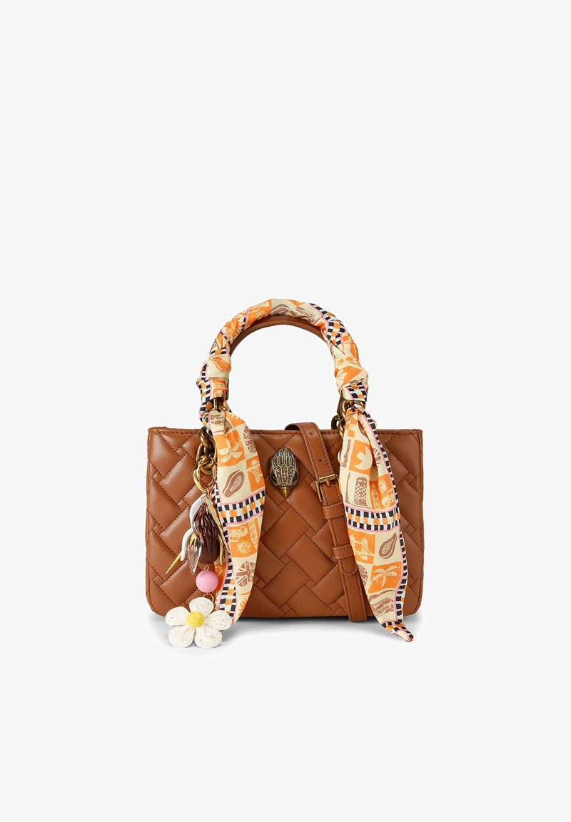 Sac à main en cuir tressé marron avec poignée enveloppée d'une écharpe orange à motifs et charms en forme de fleurs et de perles sur fond blanc.