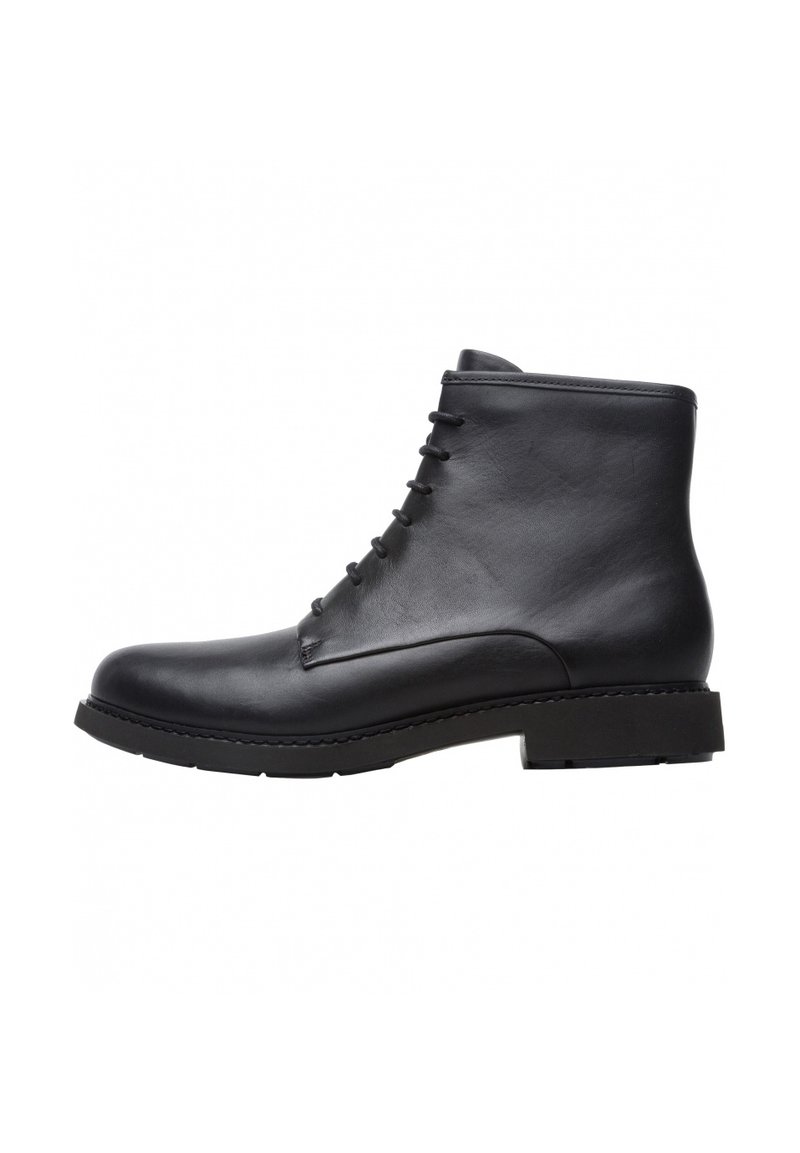 Botas de tobillo de cuero negro con punta redonda, diseño con cordones, textura suave y suela de goma resistente. Apariencia minimalista y elegante.