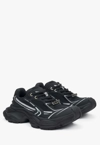 Czarne buty sportowe z teksturowaną siateczkową cholewką, odblaskowymi srebrnymi akcentami, grubymi gumowymi podeszwami oraz sznurowanym designem. Posiadają wyraźne elementy stylizacji.